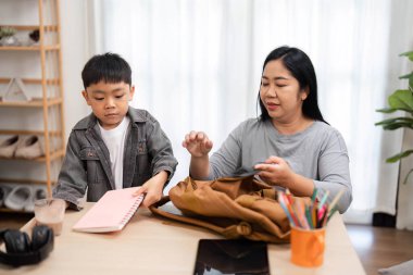 Bir anne oğlunun okul malzemelerini düzenlemesine yardım eder, gelecek okul yılına hazır olmasını sağlar ve sorumluluk duygusunu geliştirir..