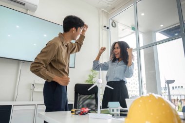 İki genç profesyonel, sürdürülebilir konut çözümlerine odaklanmış başarılı planlama oturumlarını kutlayarak, coşku ve takım çalışmalarını sergilediler..