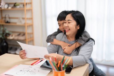 Bir anne oğullarının resim yapmasına, yakın ilişkilerini sergilemesine ve okula hazırlanırken yaratıcılığın verdiği keyfi takdir eder..