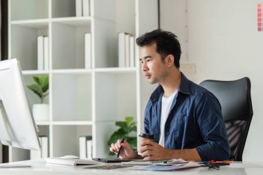 Modern bir tasarım stüdyosunda çalışan bir grafik tasarımcısı dijital araçlar ve yaratıcı bir çalışma alanı kullanıyor..