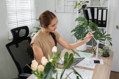 İlgili bir birey, yenilikçi yenilenebilir enerji çözümleri sunan rüzgar türbini modeli kullanan ESG sürdürülebilirlik kavramlarını sunar.