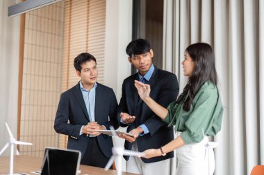 Çeşitli bir ekip, modern bir ofiste ESG sürdürülebilirlik planlama oturumuna katılarak yenilikçi fikirleri paylaşıyor..