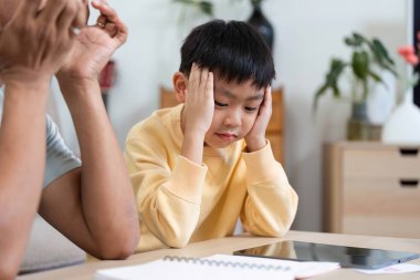 Bir baba, oğullarının evde eğitim seansında yaşadığı hayal kırıklığını gözlemleyerek, öğrenmede sabır ve desteğin önemini vurgular..