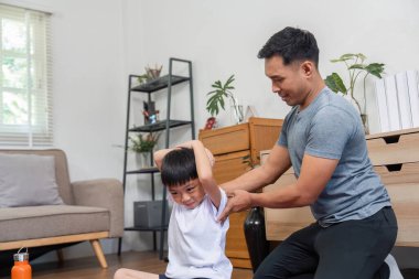 Şefkatli bir baba, evdeki esneme egzersizlerinde oğluna yardım eder. Formunu yükseltir ve aile bağları yoluyla sağlıklı alışkanlıkları teşvik eder..
