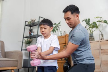 Kendini oğluna pembe ağırlık kaldırmada yardım etmeye adamış bir baba ev ortamında sağlık, güç ve aile bağlarına odaklanıyor..