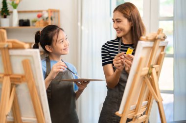 Bir anne ve kızı resim yaparken yaratıcılığı tecrübe eder. Gülümseme ve neşeyle dolu kaliteli aile zamanlarının tadını çıkarır..