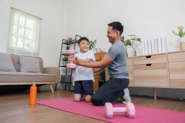 Bir baba ve oğulun spor yaparken eğlendiği iç açıcı bir sahne, güldükleri ve cesaretlendirdikleri anlar..