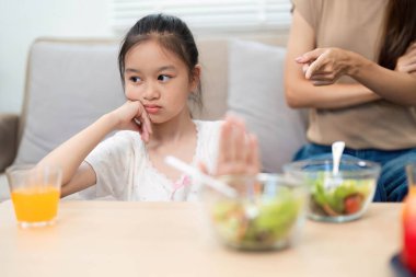 Bir kız sağlıklı salatasını yemeye karşı direnç gösterirken annesi tepki veriyor ve sağlıklı olmanın duygusal sınırlarını vurguluyor..