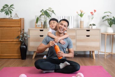 Bir baba ve oğul antrenmandan sonra keyifli bir anı paylaşıyorlar, evlerindeki spor yolculuklarında paylaştıkları bağı gösteriyorlar..