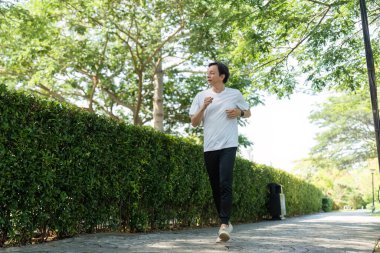 Yaşlı bir adam parkta serinletici bir koşudan zevk alır. Forma ve sağlığa olan bağlılığını gösterir..