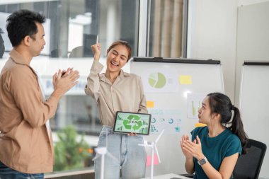 ESG ölçümleri ve sürdürülebilir iş uygulamaları hakkında işbirlikçi bir ofis ortamında tartışmalara giren dinamik bir ekip.