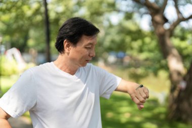 Bir adam, dışarıda geçirdiği bir anın tadını çıkarırken, sağlık ve zindelik takibinin önemini vurguluyor..