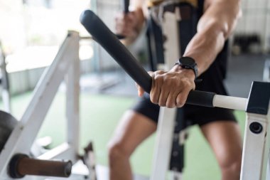 Spor aletlerini sıkıca kavrayan güçlü bir el görüntüsü, kuvvet eğitimini ve fitness adanmışlığını vurguluyor.