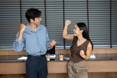 Modern bir ofis ortamında ilk pompalarla heyecan ve motivasyon ifade eden iki profesyonel..