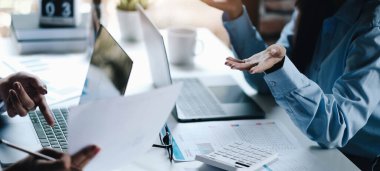 Sonuçları gösteren grafikleri ve grafikleri tartışan iki lider iş kadını.