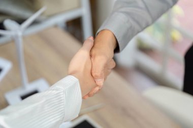 Modern ofis ortamında ESG girişimlerine olan bağlılığını vurgulayan iki profesyonelin yakın çekimi.