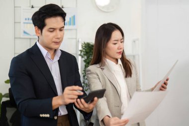 İki profesyonel proje belgesi, stratejileri ve görüşleri parlak, modern ofis ortamında tartışıyor..