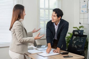 Modern ofis ortamında proje stratejileri ve fikirleri hakkında canlı bir tartışmaya giren iki iş adamı..