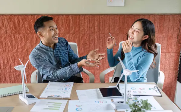 Bir erkek ve kadın, modern bir ofiste ESG girişimlerini tartışıyor, sürdürülebilirlikte işbirliği ve yenilik sergiliyor.