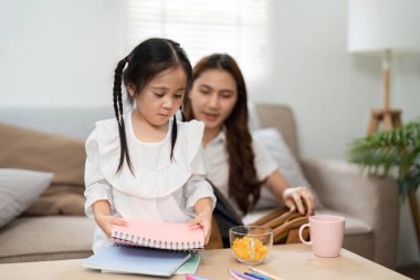 Okul malzemelerini sıralarken, anne ve kızı okula geri dönmenin heyecanını gösteren bir anı paylaşıyorlar..