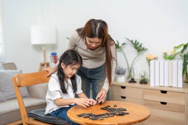 Bir anne ve kızı etkileşimli bir oyun seansından zevk alıyorlar, oyun parçaları ile birlikte çalışarak bağ kurmayı ve öğrenmeyi teşvik ediyorlar..