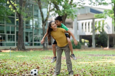 Kız ve erkek, sırtına binmenin keyfini çıkarırken neşeli bir bağ sergilerler. Bir futbol topu yakınlarda durur ve açık hava aktivitelerine olan sevgilerini ima eder..
