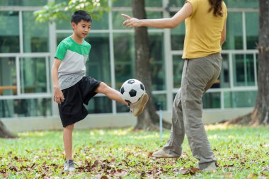Bir kız onu cesaretlendirirken, bir erkek futbol antrenmanı yapar. Günlük aktivitelerinde oynamanın ve egzersiz yapmanın önemini vurgular..