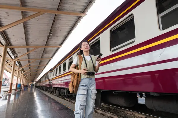 Bir gezgin heyecanlı bir tren istasyonunda heyecanla trenini bekliyor, maceraya hazır. Telefonunu gülümseyerek kontrol ediyor. Keşif ruhunu somutlaştırıyor..