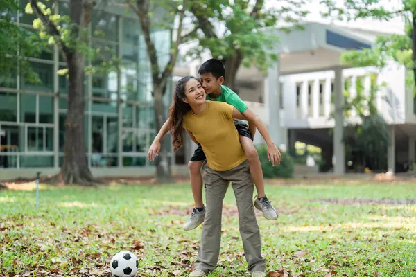 Kız ve erkek, sırtına binmenin keyfini çıkarırken neşeli bir bağ sergilerler. Bir futbol topu yakınlarda durur ve açık hava aktivitelerine olan sevgilerini ima eder..