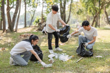 Bir grup gönüllü bir parkı temizlerken atık ayıklıyor, sürdürülebilirliği ve takım çalışmasını destekliyor.