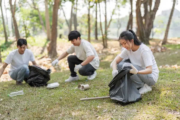 Bir grup arkadaş bir park temizliğine, takım çalışması sergilemeye ve sürdürülebilirliğe bağlılığa katılıyor..