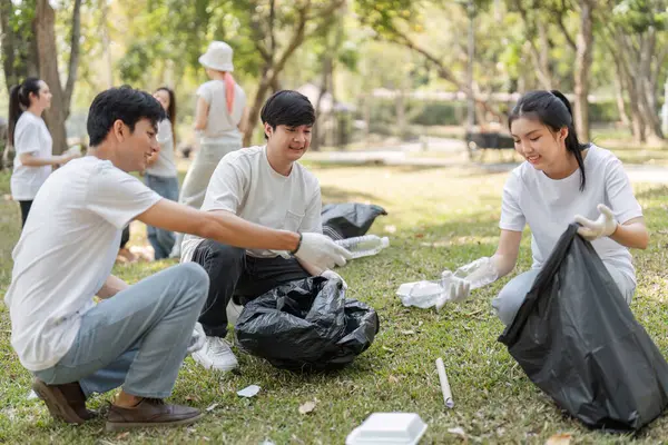 Bir grup genç gönüllü, çevre sürdürülebilirliği ve kamu hizmetine olan bağlılıklarını göstermek için bir park temizliğinde işbirliği yapıyor..