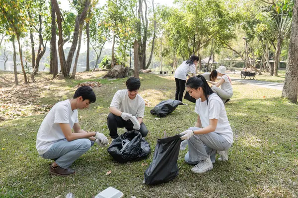 Bir grup hevesli gönüllü bir toplum temizliğine katılıyor, özenle atık topluyor ve çevre sorumluluğunu destekliyor.