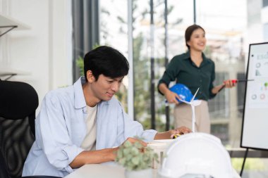 İki meslektaş sürdürülebilir mimari, takım çalışması ve parlak bir ofis ortamında yenilik hakkında verimli bir tartışmaya giriştiler..