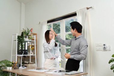 İki iş adamı, çalışma alanlarındaki ESG girişimlerine ilişkin coşku ve takım çalışmalarını yansıtan bir beşliği paylaşıyor..