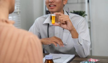 Bir sağlık uzmanı, bir hastanın muayenesi sırasında elinde reçeteli ilaç şişesi bulundurmaktan bahseder..