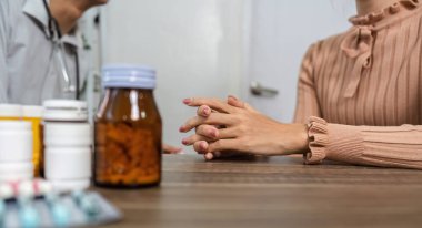 Bir doktor ve hasta, birlikte ilaç ve tedavi seçeneklerini tartışarak, hastaların sağlığı hakkında detaylı bir konuşma yapar..