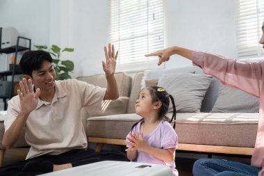 Bir anne ve baba, eğlenceli jestler kullanarak kızlarını oyun zamanı boyunca cesaretlendirir ve yaklaşan seyahatlerini kutlarken onlarla bağlantı kurarlar..