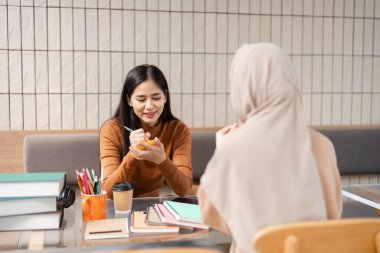 İki arkadaş, çalışma stratejilerini ve kaynaklarını paylaşırken rahat bir kafe ortamının tadını çıkarırken, hareketli bir sohbet başlıyor..