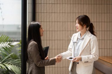 İki profesyonel, iş stratejileri dahilinde sürdürülebilirlik ve yeniliğe ortak kararlılıklarını temsil ederek, el sıkışarak ortaklıklarını sağlamlaştırıyor..