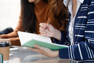 İki kendini adamış öğrenci aynı fikirleri paylaşıyor ve sıcak kahvenin tadını çıkarırken not alıyor, öğrenme olanağı sağlayan işbirlikçi bir atmosfer sağlıyor..
