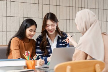 Üç arkadaş birlikte çalışır, görevleri üzerinde çalışırken kahkahalarını ve sezgilerini paylaşırlar. Atmosfer işbirlikçi öğrenmenin hazzını vurgular..