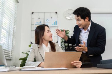 Modern ofis ortamında finansal veri ve stratejileri tartışan erkek ve kadın bir profesyonel takım çalışması sergiliyor.