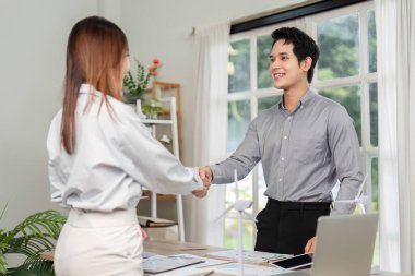 İki iş adamı el sıkışarak, sürdürülebilirlik ve yenilik odaklı bir ESG projesi üzerinde anlaşma sağladı..