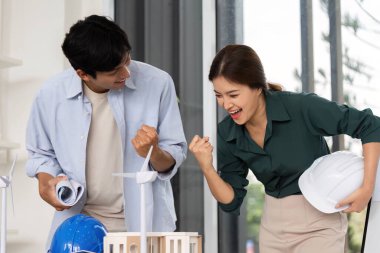 İki mimar arasında neşeli bir an. Projelerini kutluyorlar. Çağdaş bir çalışma alanında başarı, takım çalışması ve yenilik..