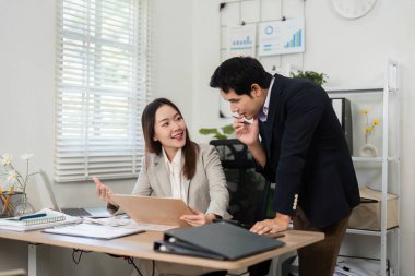 Bir mali danışman ve müvekkili, parlak bir ofis alanındaki yatırım seçenekleri ve stratejileri hakkında verimli bir konuşma yapıyorlar..