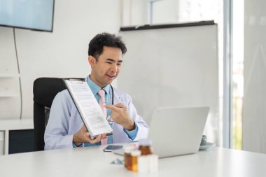 Doktor, bir tele sağlık ziyareti sırasında tıbbi dokümanları göstererek, hasta anlayışını ve katılımını destekleyerek profesyonelliğini gösteriyor..