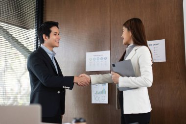 Bir erkek ve bir kadın, başarılı bir anlaşmayı sembolize ederek, projelerinin amaçları ve karşılıklı faydalarını tartıştılar..