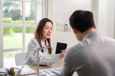 Bir kadın, iş toplantısında yenilenebilir enerji çözümlerini tartışıyor, ESG değerlerini ve sürdürülebilir uygulamaları vurguluyor.