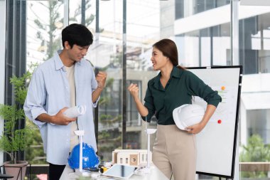 Mühendisler, proje başarılarından duydukları heyecan ve neşeyi parlak bir ofis alanında, takım çalışması ve yenilik sergileyerek ifade ediyorlar..